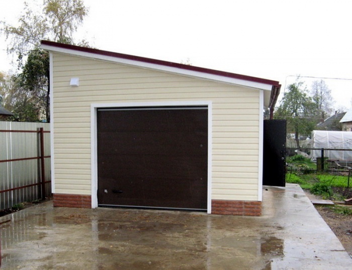 Оценить внешний вид гаража с двускатной крышей поможет фото пример: